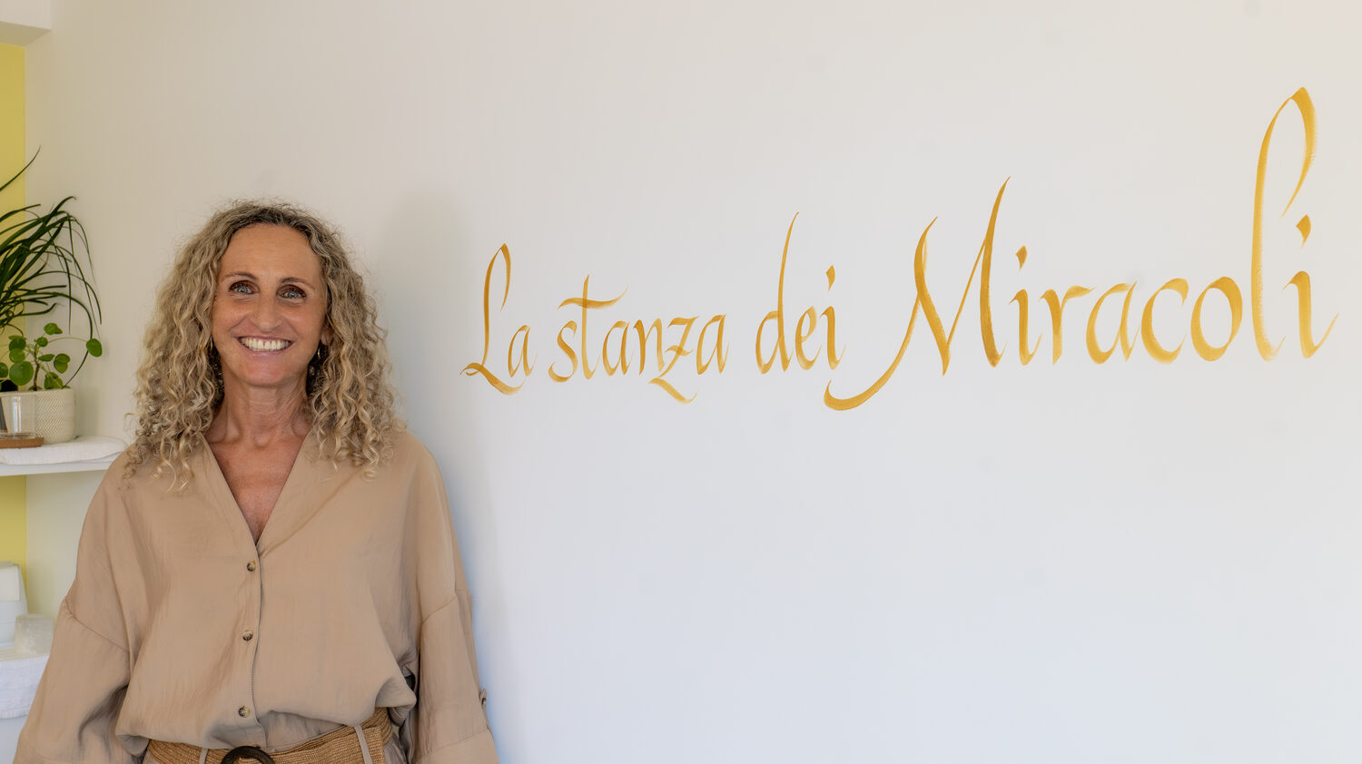 Isabelle Pedroli nel suo studio, accanto alla scritta La stanza dei Miracoli